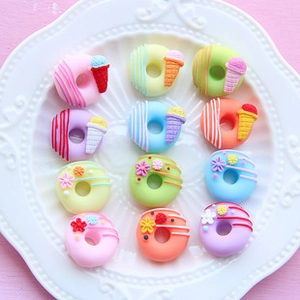 Macro shot of 12 colorful resin donuts and ice cream cone charms for DIY phone cases