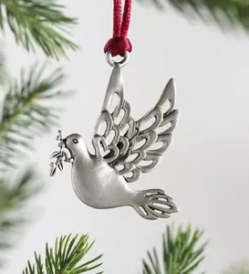 Close-up of a silver peace dove Christmas ornament with hollow wings on a green tree branch