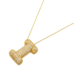 Macro detail of gold-plated balloon letter I pendant with sparkling cubic zirconia stones