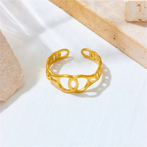 Detail of adjustable matte gold hollow interlocking oval ring on textured stone