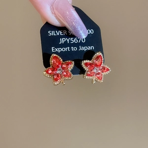 Close-up of S925 silver red maple leaf earrings with sparkling gemstone clusters