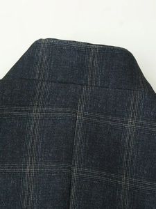 Detail shot of the rear neckline and shoulder seam of a dark plaid blazer jacket