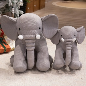 Set of two soft gray elephant plush toys with textured fabric in a cozy home setting