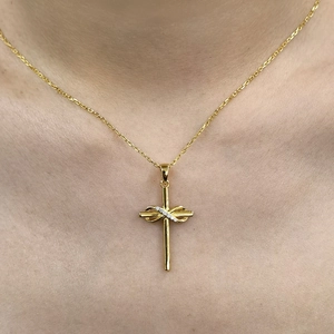 Close-up of gold infinity cross necklace with white rhinestones on a female neck