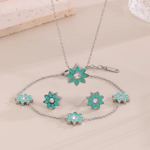 Vue détaillée d'une parure en acier inoxydable avec motifs de fleurs en émail turquoise