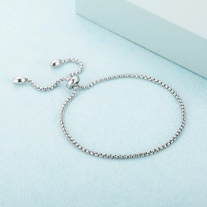 Minimalist adjustable silver box chain bracelet with sliding clasp on blue background