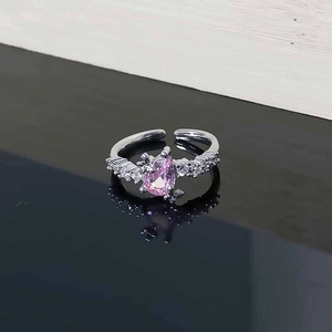 Detail of silver adjustable ring with pink pear-cut zircon and white crystal accents