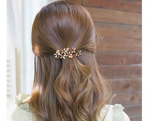 Detail of floral hair clip with pearls and rhinestones on half-up hairstyle
