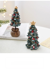 Close-up of resin mini Christmas trees with festive decorations and burlap base