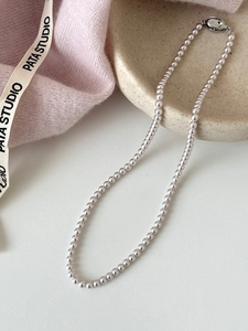 Gros plan du fermoir en argent S925 avec gravure 925 sur un collier de perles roses
