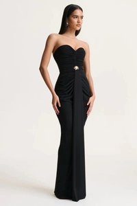 Detail of elegant black strapless maxi dress featuring ruching and gold metal waist accent