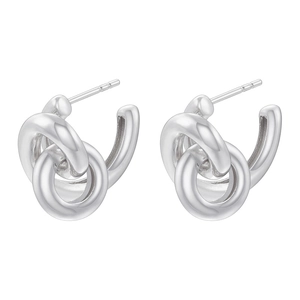 Close-up of silver knot earrings with architectural lines and metallic luster