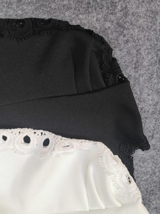 Gros plan sur un tissu côtelé noir et blanc avec des détails de broderie en dentelle