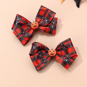 Detailed view of Halloween hair bows with red black plaid fabric and glitter pumpkin accents