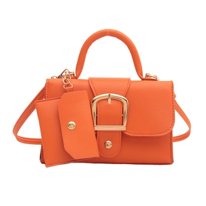 Ensemble sac bandoulière orange avec boucle carrée dorée et porte-monnaie assorti sur blanc