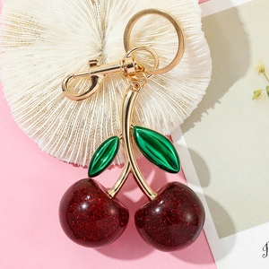 Detailed view of luxury cherry keychain with gold metallic leaves and glittery red berries