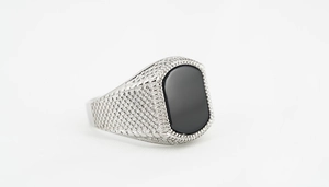 Detail of vintage punk titanium steel ring with black square stone and side texture