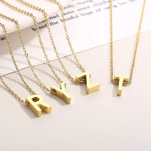Close-up of gold 3D initial letter pendants R Y Z T on delicate stainless steel chains