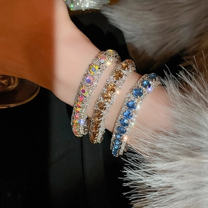 Detailed view of three luxury wide bracelets with multi-color rhinestones inlay on wrist