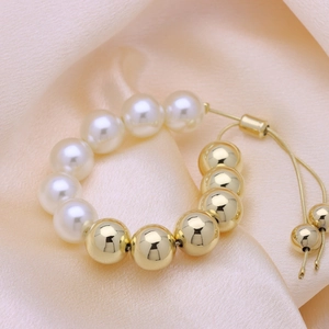 Adjustable 18k gold plated beaded bracelet with white pearls on champagne silk background