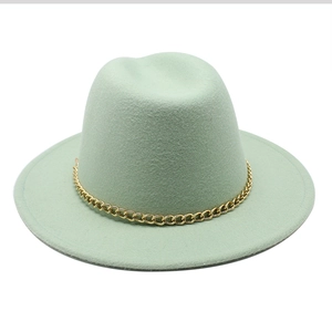 Detail of mint green fedora wool hat with a decorative bold gold chain band