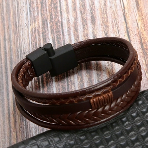 Detailed macro view of brown braided leather layers and a sleek black magnetic clasp