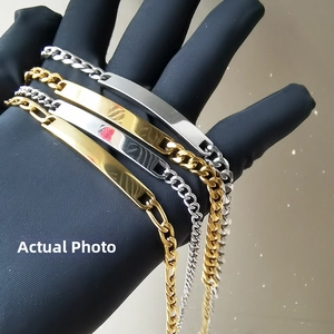 Makroaufnahme von ID-Armbändern mit Panzerkette in Gold und Silber auf schwarzen Handschuhen