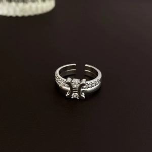 Macro shot of silver bow heart open ring with brilliant zircon stones on dark leather
