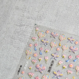 Detail of embossed nail stickers featuring traditional paper fans and kites motifs