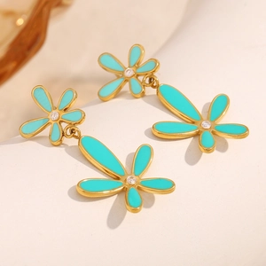 Detail of flower-shaped earrings with blue enamel petals and a sparkling zircon center