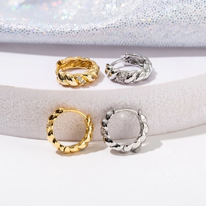 Gedrehte 18K Gold und Silber Creolen mit Diamantbesatz auf weißem Display-Podest