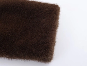 Macro shot of dark brown faux fur texture showing soft plush fabric fibers and detail