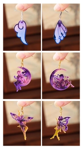 Detail of glitter purple resin wing and moon fairy earrings with gold and silver hooks