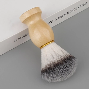 Macro view of wooden handle shaving brush with soft synthetic bristles and gold metal ring