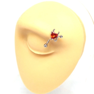 Detail of red heart zircon devil eyebrow piercing ring on a silver punk body jewelry