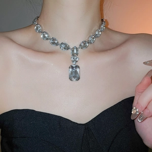 Detail einer luxuriösen Tropfen- und Kristallkette am Ausschnitt des Models