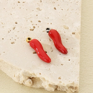 Detailed close-up of two red chili pendants with gold and silver loops for DIY jewelry