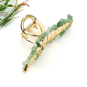 Detailed view of natural green crystal stones hand-wrapped on a golden alloy hair claw clip