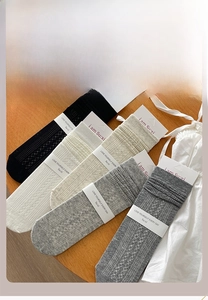 Detailed close-up of knit crew socks with hollow patterns in five neutral colors