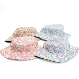 Detailed flat lay of cotton bucket hats featuring colorful floral prints in four shades