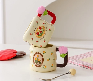 Detail of cream ceramic mugs with 3D tulip handles and floral spring patterns