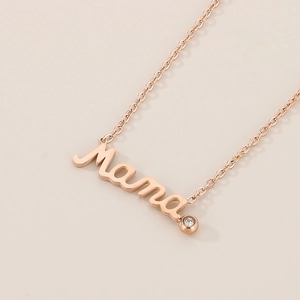 Detail of rose gold Mama necklace pendant featuring a small sparkling diamond accent
