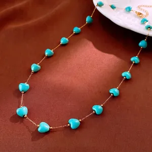 Retro golden necklace with sky blue heart-shaped turquoise beads on dark velvet