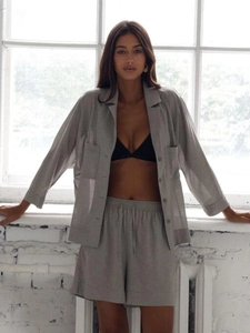 Detail of gray linen shirt set showing oversized pockets and textured fabric surface