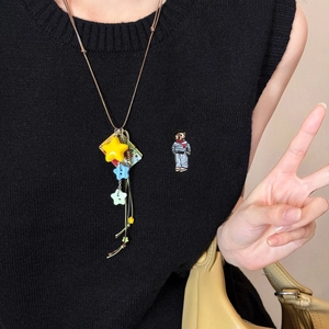 Detail of creative acrylic star charms on a long cord necklace with a retro card design