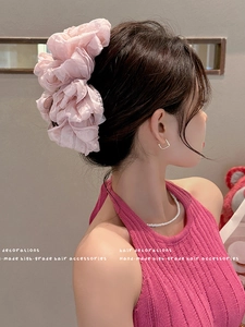 Detail of a large pink ruffled organza scrunchie on hair for a voluminous aesthetic