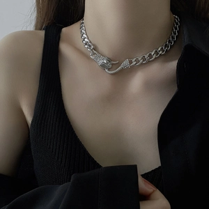 Detailaufnahme der silbernen Gliederkette mit funkelndem Schlangenanhänger und Strass