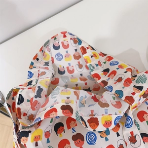 Detailed close-up of a soft cotton crossbody bag featuring colorful cartoon character prints