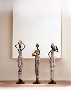 Three African tribal women figurines with geometric patterns displayed on a sideboard