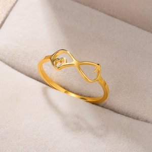 Macro view of gold infinity heart ring nestled in a beige velvet jewelry box